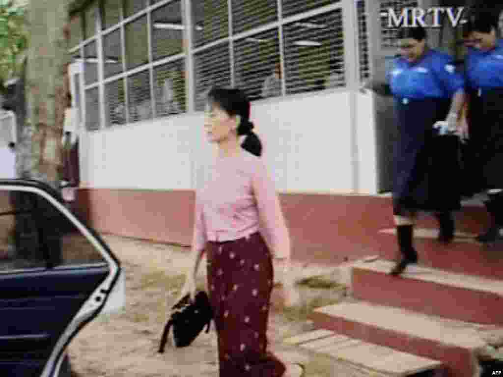 Myanmar -- A screen capture of an MRTV television broadcast shows Nobel Peace Prize winner Aung San Suu Kyi (L) as she is escorted to a car on the third day of her trial at Yangon's Insein Prison, 20May2009 - MYANMAR, YANGON : MYANMAR OUT A screen capture of an MRTV television broadcast shows Nobel Peace Prize winner Aung San Suu Kyi (L) as she is escorted to a car on the third day of her trial at Yangon's Insein Prison on May 20, 2009. British Foreign Secretary David Miliband on May 21 called on Myanmar to stop the 'charade' of democracy icon Aung San Suu Kyi's trial, as the junta again barred media and diplomats from the court.