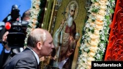 Президент России Владимир Путин целует в Киеве икону святого Владимира на одном из мероприятий, посвященных 1025-летию Крещения Руси. Киев, 27 июля 2013 года.