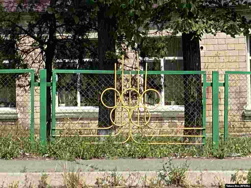 O parte din gardul Liceului Teoretic din Peresecina, Orhei, amplasat de-a lungul traseului Chișinău-Bălți, încă păstrează simbolul Jocurilor Olimpice din 1980 din Moscova.