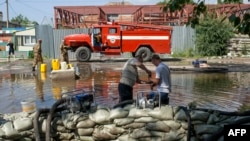 Russian emergency workers erect a dam in a flooded street in Khabarovsk on August 21.