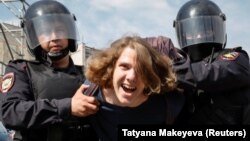 Полицейские задерживают девушку, участвовавшую в акции протеста «Он нам не царь». Москва, 5 мая 2018 года.