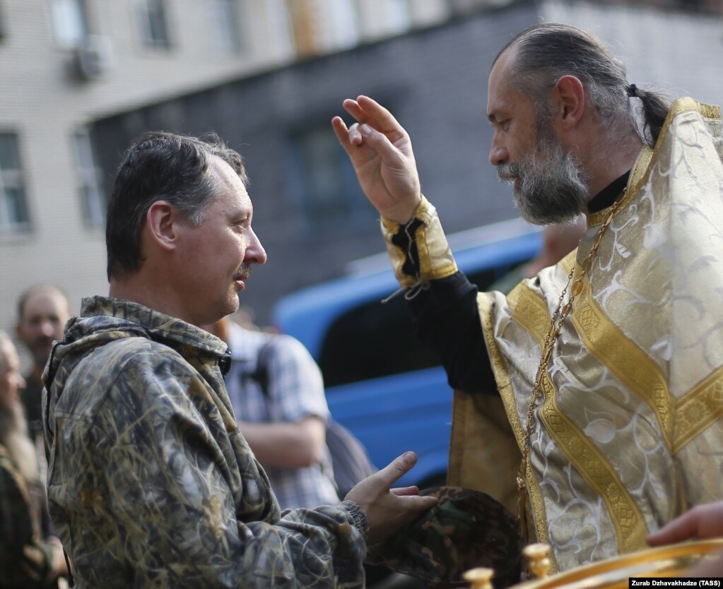 Священник благословляє російського полковника Ігоря Гіркіна (Стрєлкова), який на той час був одним із ватажків угруповання «ДНР», що визнане в Україні терористичним. Окупований Донецьк, 10 липня 2014 року