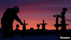 A worker checks the valve of a pipe at an oil field in Bashkortostan, Russia.