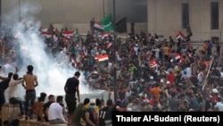 Demonstrators disperse as Iraqi Security forces use tear gas during a protest against government corruption amid dissatisfaction at lack of jobs and services at Tahrir square in Baghdad, Iraq October 1, 2019. 