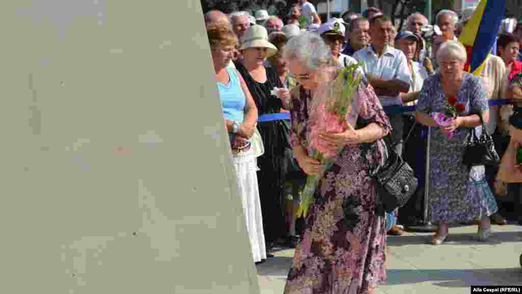 Valentina Sturza, president of the association of former political prisoners and deportees, lays a wreath.