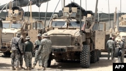Американские солдаты рядом со своей бронетехникой на базе в пригороде Багдада Мадинат-эс-Садр, Ирак, 11 июня 2009 года