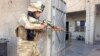 An Iraqi security forces member takes his position with his weapon during clashes with Al-Qaeda-linked militants in the city of Ramadi on February 11.