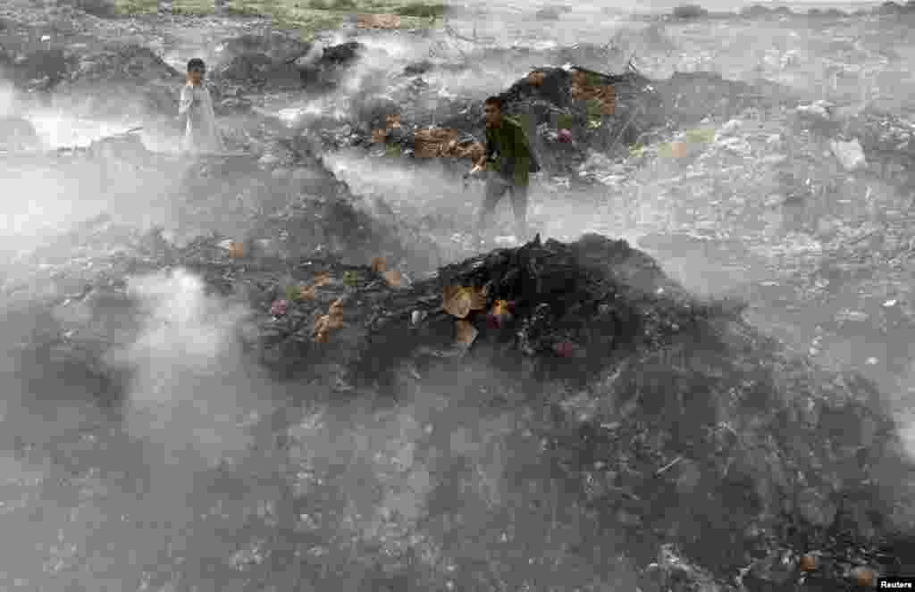 Boys collect recyclables from a pile of smoldering garbage at a dump on the outskirts of Karachi, Pakistan. (Reuters/Akhtar Soomro)