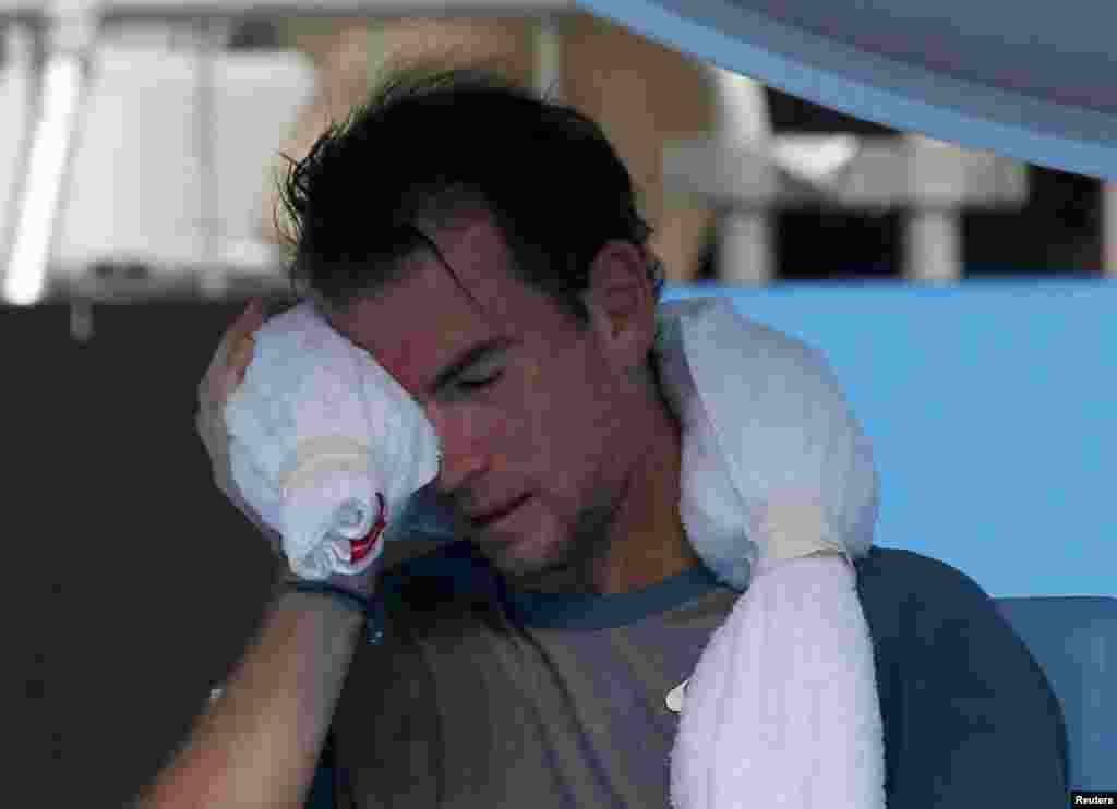 Adrian Mannarino of France holds an ice pack to his face during his men&#39;s singles match against David Ferrer of Spain on January 15.