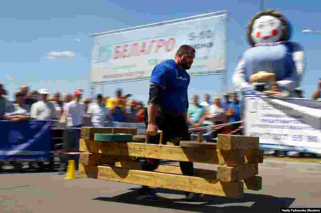 A man carries a 330-kilogram piece of equipment during the international Nortec Strongman Cup 2018 on the outskirts of Minsk. (Reuters/Vasily Fedosenko)