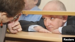Vladimir Kozlov looks out from a glass-walled cell during his trial in the city of Aqtau last month.