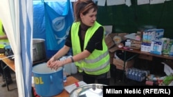 Volonteri pripremaju hranu za ljude koji pristižu