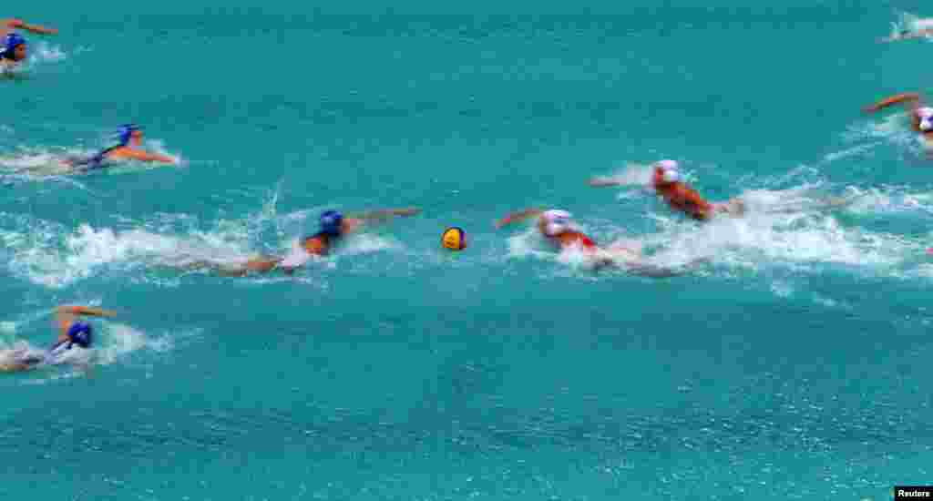 Spanish and Hungarian players start their preliminary-round water polo match.