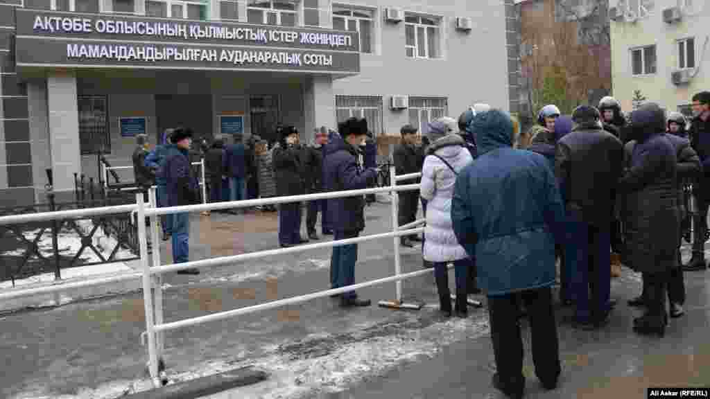 Желающие присутствовать в суде при оглашении приговора по делу об июньских нападениях в Актобе стоят в очереди перед зданием специализированного межрайонного суда по уголовным делам Актюбинской области. 28 ноября 2016 года.