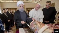 Pope Francis (center right) and Iranian President Hassan Rohani (center left) exchange gifts during their private audience at the Vatican on January 26.