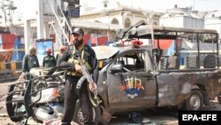 A Pakistani soldier guards the Police vehicle targeted outside the Sufi Muslim Data Gunj Buksh shrine in Lahore on May 8.