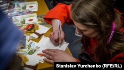 Зрители подписывают открытки Олегу Сенцову и Александру Кольченко на фестивале Docudays UA. Киев, 25 марта 2017 года