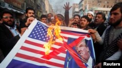 Pakistanci u Pešavaru pale američku zastavu uz koju stoji slika Donalda Trumpa