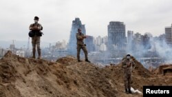 سربازان لبنانی ایستاده بر روی ویرانه‌های پس از انفجار مهیب روز ۱۴ مرداد بیروت