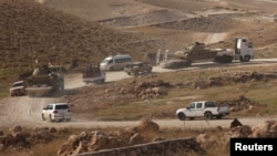 Vehicles belonging to Kurdish Peshmerga forces are seen in the town of Sinjar on November 12.