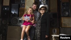 Pyotr Verzilov, husband of convicted Pussy Riot band member Nadezhda Tolokonnikova, holds his daughter Gera as he accepts the Lennon Ono Grant for Peace from Yoko Ono in New York on September 21.