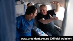 Владимир Балух и Эдем Бекиров в самолете во время возвращения в Киев в рамках обмена удерживаемыми лицами между Украиной и Россией, 7 сентября 2019 года