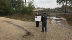 Eskender Abdulganiyevniñ anası Emine yazuvlı şiarınen (Foto: Qırım birdemligi)