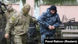 Працівник російської ФСБ веде українського моряка в будівлю підконтрольного Кремлю суду в Сімферополі, 27 листопада 2018 року