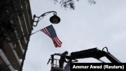 Izrael: Një punëtor vendos flamurin amerikan në një shtyllë që gjendet në rrugën ku ndodhet konsullata e SHBA-së në Jerusalem. 6 dhjetor, 2017