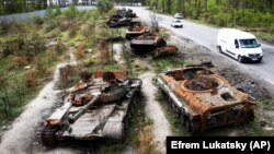 Cars pass by destroyed Russian armored vehicles outside Kyiv late last month. Although the Kremlin has failed in its initial bid to take his country's capital, Ukrainian lawmaker and special forces commander Roman Kostenko believes Moscow hasn't abandoned its ambitions to take the city. 
