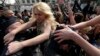 Ukrainian activist Inna Shevchenko (center) and other members of the women's rights group Femen struggle with police officers during a protest in Paris in April 2013.