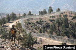 A soldier stands guard along the border fence at the Angoor Adda outpost on the border with Afghanistan in South Waziristan. (file photo)