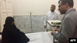 Afghan Consul-General Abdul Waheed Poyan (right) talks with Sharbat Gula in a hospital in Peshawar on November 2.