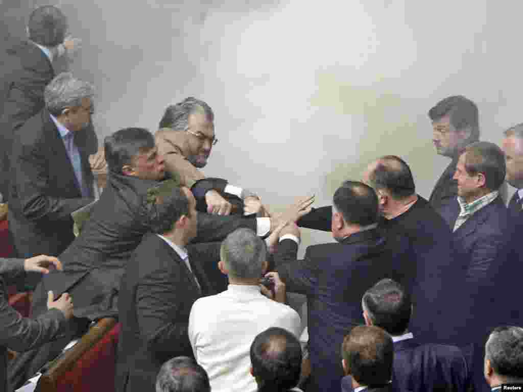 Deputies scuffle during a session of the Ukrainian parliament in Kyiv on April 27. Opposition lawmakers hurled eggs and smoke bombs inside the chamber as lawmakers approved an agreement allowing Russia's Black Sea Fleet to stay at Sevastopol until 2042. Photo by Gleb Garanich for Reuters