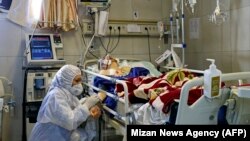 An Iranian medic treats a patient infected with the COVID-19 virus at a hospital in Tehran, March 1, 2020