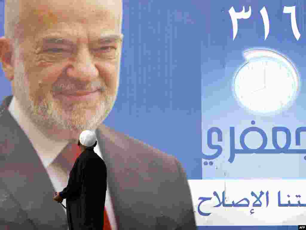 A man looks at a campaign poster of former Prime Minister Ibrahim al-Ja'afari stating "Our mission is reform." - Iraqi politicians this week started campaigning for the March 7 general election amid a heated political atmosphere. Photo by Ali Al-Saadi for AFP