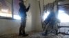 UN experts, wearing gas masks, inspect one of the sites of an alleged chemical weapons attack in a Damascus suburb last month. 