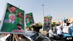 Supporters of Nawaz Sharif carry their party leaders' portraits during March 12 protest rally in Karachi