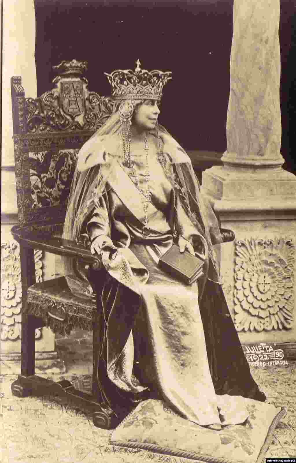 Regina Maria, în costumul de mare ceremonie de la Încoronarea alături de Regele Ferdinand, ca suverani ai României Unite, 15 octombrie 1922. Ferdinand a devenit rege în vreme de război, după moartea regelui Carol I, în septembrie 1914. Prin urmare, cuplul regal nu avusese o ceremonie de înscăunare. Înocronarea a fost cea mai mare sărbătoare a epocii din întreaga Europă Centrală și de Est, cu invitați de prestigiu din întreaga lume. În România, serbările publice au ținut vreme de trei zile.&nbsp;