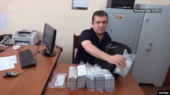 Vachagan Ghazarian empties his bag filled with cash after being arrested by the National Security Service in Yerevan