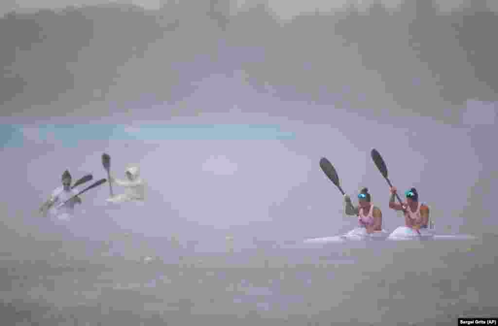 Contestants brave strong rain as they prepare to compete in the women's K2 canoe sprint 200-meter final during the Second European Games in Zaslavl, Belarus. (AP/Sergei Grits)