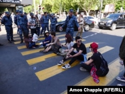 A driver and a policeman argue with students blocking an intersection in the center of Yerevan on April 25.