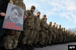 Militari ucraineni cu un portret al lui Putin.