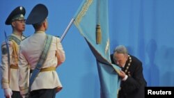 No kiss goodbye: Kazakh President Nursultan Nazarbaev kisses the national flag during his inauguration ceremony for a fourth term in Astana on April 8.