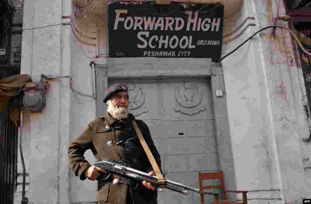 A policeman stands guard in front of a school soon after a militant attack killed more than 20 students and teachers at Bacha Khan University on January 20.