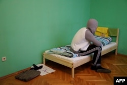 A Chechen man who fled the republic due to his sexual orientation sits on his bed in Moscow on April 17.