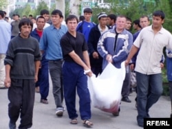 People carry away dead bodies after the Andijon crackdown in May 2005.