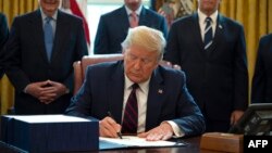 Президент США Дональд Трамп підписує фактично історичний документ у Білому домі, 27 березня 2020 року