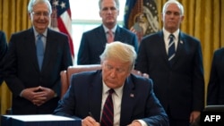 Президент США Дональд Трамп (на переднем плане) ставит подпись под законопроектом. Иллюстративное фото.