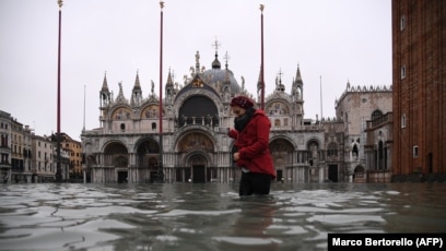 Një grua ecë pranë bazilikës së Shën Markut në Venecia.